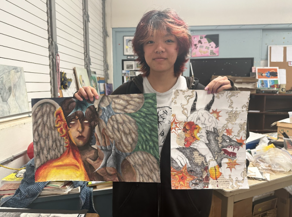 Russet Sounthala (11) holds up two art pieces he made during his Drawing & Painting class. 