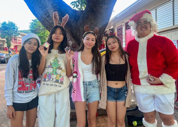 Taylor Wong (10), Yuna Otsuka (11), Suzue Showers (11), Abby Nii (11), and Shea Brown (12) stand under a tree handing out small christmas candies and treats. Wong wears a Santa hat, Otsuka, Showers, and Nii wear reindeer ears and Brown wears a whole Santa suit. Tuesday, Dec. 18, Kalani’s third day of Spirit Week, “Santa’s Workshop” (Christmas Accessories).